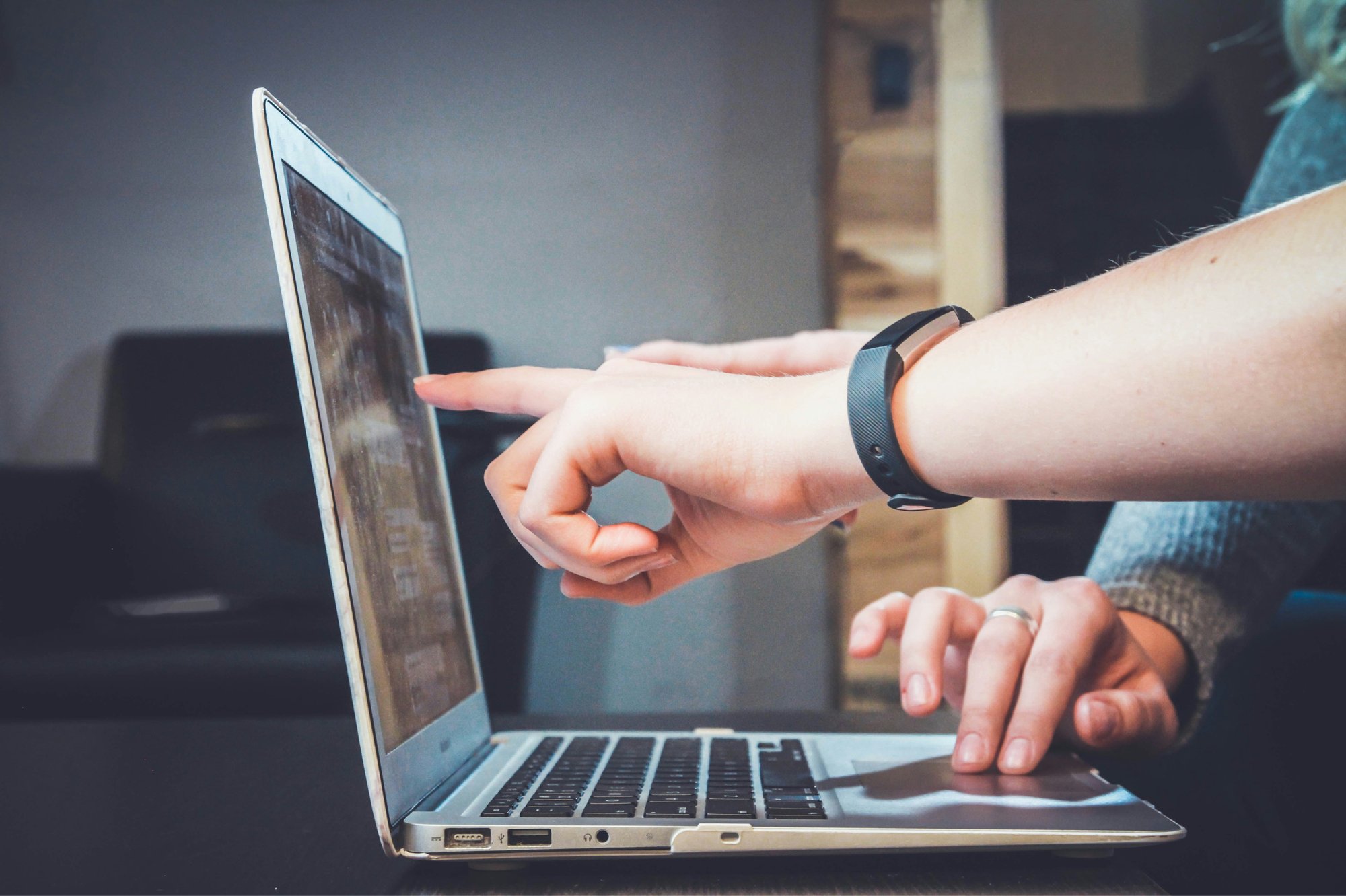 Hand pointing at a computer screen