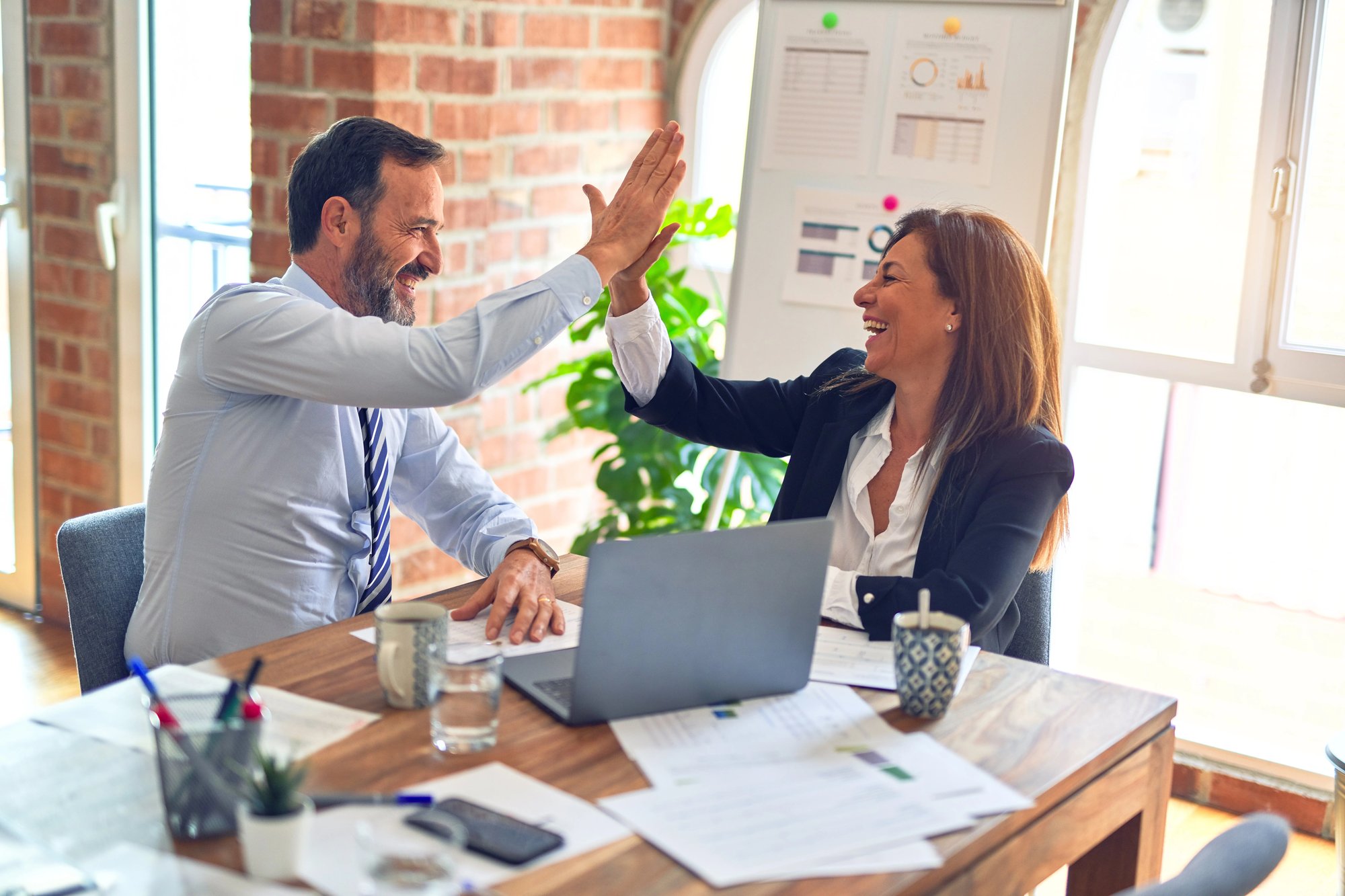 Two colleagues high-five and smile